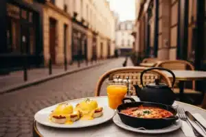 Brunch en terrasse dans le Marais : oeufs Benedict, shakshuka, jus d'orange et ruelle pavée en arrière-plan
