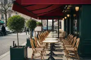 Meilleur restaurant à Paris : terrasse d'un bistrot parisien avec store rouge et chaises en rotin