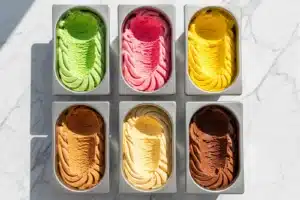 Bacs de glaces artisanales colorées sur comptoir en marbre blanc, meilleure glace de Paris