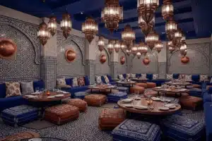 Salle d'un restaurant halal à Paris avec carreaux de zellige bleu et blanc et lanternes en cuivre