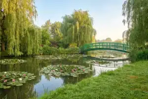 Le pont japonais de Giverny surplombant un étang couvert de nymphéas roses, pour visiter Giverny depuis Paris