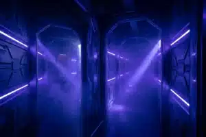Couloir futuriste d'une arène de laser game à Paris avec néons bleus et violets dans la brume