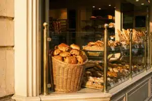 Pain au chocolat doré dans la vitrine d'une boulangerie parisienne artisanale, au lever du soleil