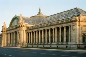 La façade en pierre et la verrière du Grand Palais à Paris sous une lumière dorée